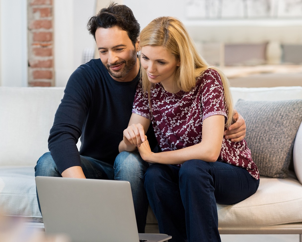 bigstock-Young-couple-sitting-on-sofa-a-121789514