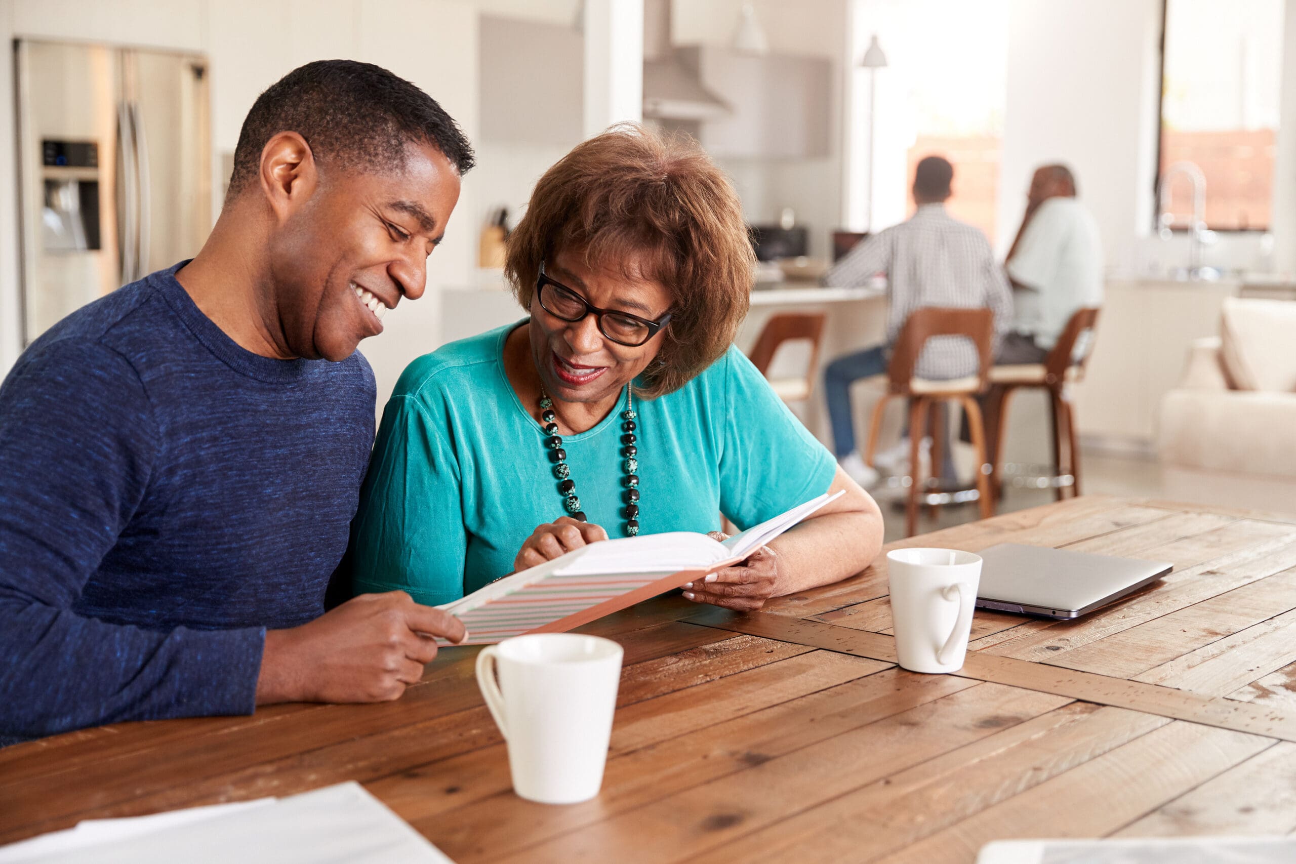 Middle aged black man looking through a photo album with his mot An adoptive parent being screened at an adoption agency in jackson tn